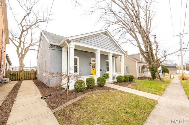 greek revival inspired property with a porch and brick siding