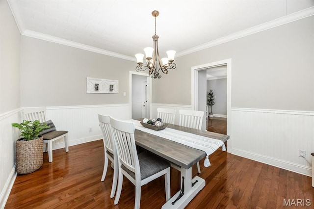 dining space featuring a chandelier, wainscoting, wood finished floors, and ornamental molding