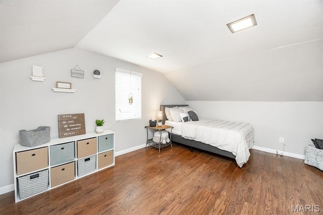 bedroom with vaulted ceiling, baseboards, and wood finished floors