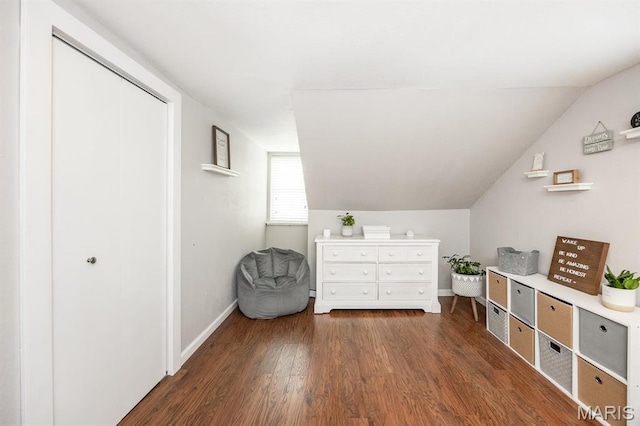 bedroom featuring wood finished floors, baseboards, and lofted ceiling