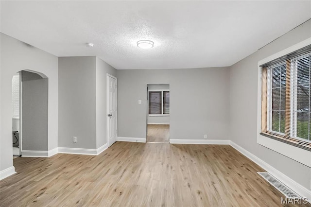 5537 Helen Ave, Saint Louis, MO 63136 - unfurnished room with arched walkways, wood finished floors, baseboards, and a textured ceiling