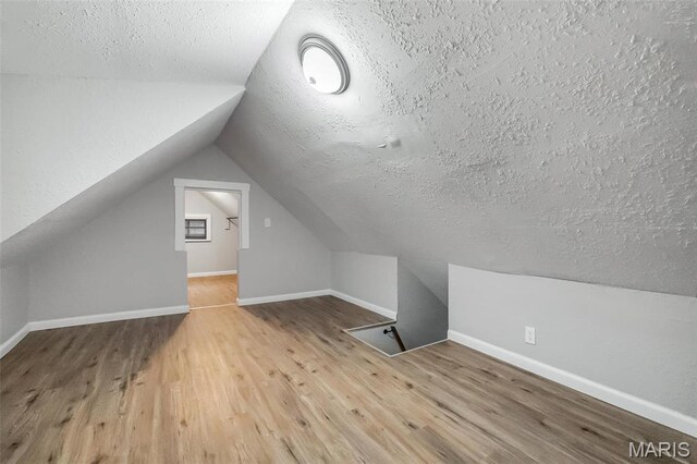 5537 Helen Ave, Saint Louis, MO 63136 - additional living space featuring wood finished floors, a textured ceiling, lofted ceiling, and baseboards
