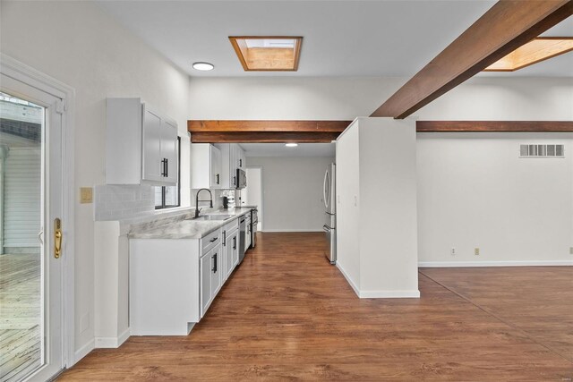 7 Beavertail Ct, Florissant, MO 63033 - kitchen with beam ceiling, a sink, light countertops, stainless steel appliances, and backsplash