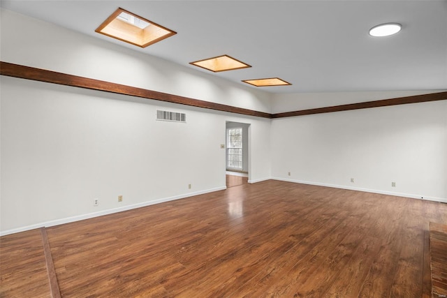 7 Beavertail Ct, Florissant, MO 63033 - unfurnished room featuring dark wood-type flooring, a skylight, baseboards, and vaulted ceiling