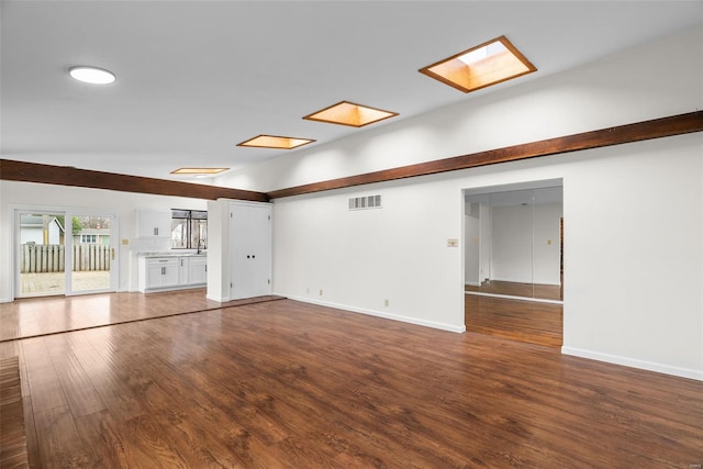 7 Beavertail Ct, Florissant, MO 63033 - unfurnished living room with wood finished floors, lofted ceiling, a skylight, and baseboards