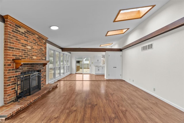 7 Beavertail Ct, Florissant, MO 63033 - unfurnished living room with a brick fireplace, wood finished floors, baseboards, and lofted ceiling