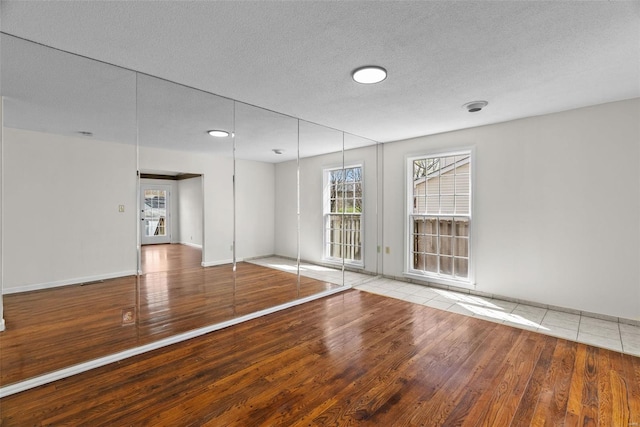 7 Beavertail Ct, Florissant, MO 63033 - spare room featuring hardwood / wood-style flooring, a textured ceiling, and baseboards