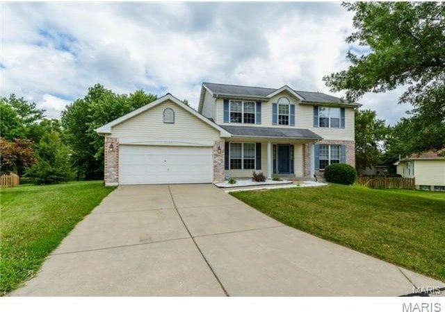 1209 Riva Ridge Ct, Florissant, MO 63034 - view of front facade featuring concrete driveway, an attached garage, and brick siding