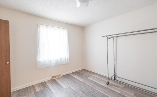 10757 Kilpatrick Cir, Rolla, MO 65401 - unfurnished bedroom with wood finished floors, a closet, baseboards, and a textured ceiling