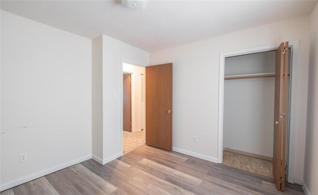 10757 Kilpatrick Cir, Rolla, MO 65401 - unfurnished bedroom with light wood-style flooring, a closet, and baseboards