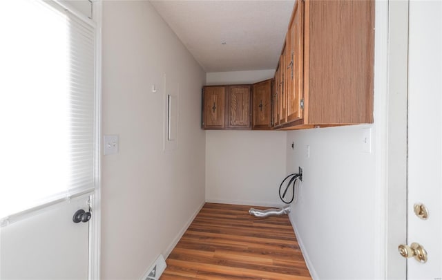 10757 Kilpatrick Cir, Rolla, MO 65401 - washroom featuring washer hookup, cabinet space, dark wood finished floors, and baseboards