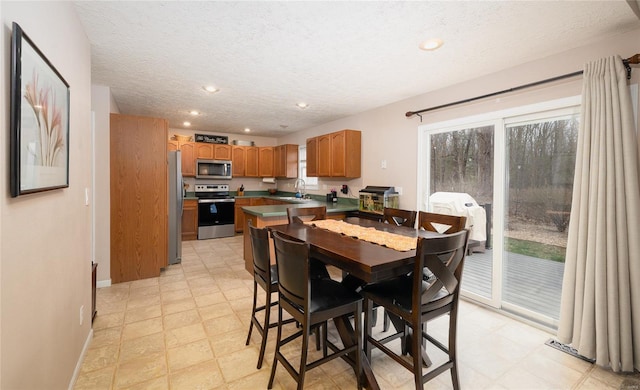 1205 Britt Ln, Rolla, MO 65401 - dining room featuring a textured ceiling, recessed lighting, baseboards, and light floors