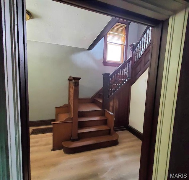 stairs featuring wood finished floors and baseboards