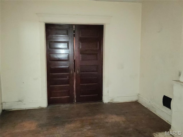 empty room with dark wood finished floors and baseboards