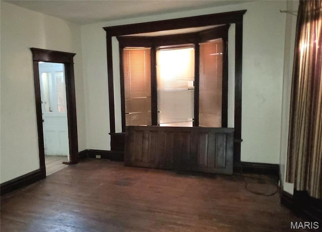 spare room with wood finished floors and baseboards