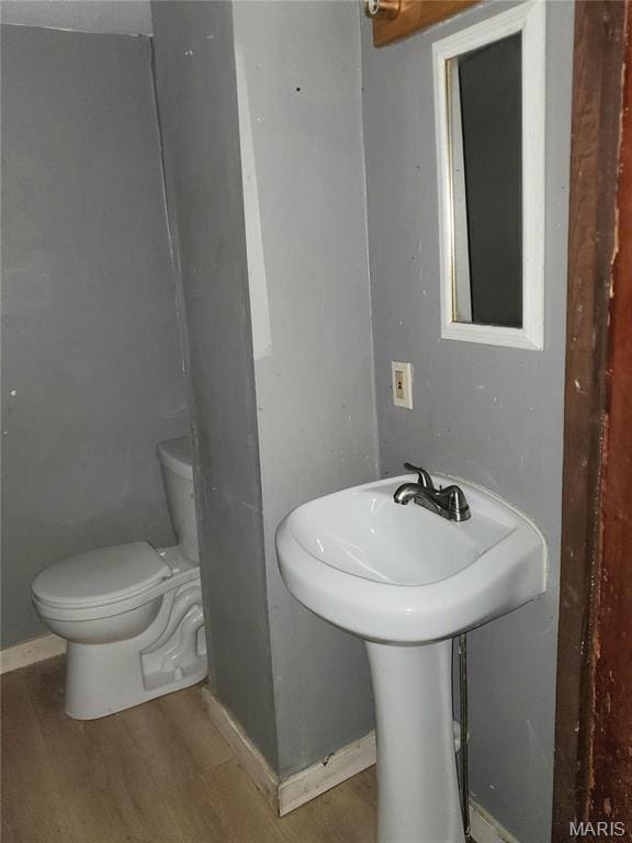 bathroom featuring toilet, wood finished floors, and baseboards