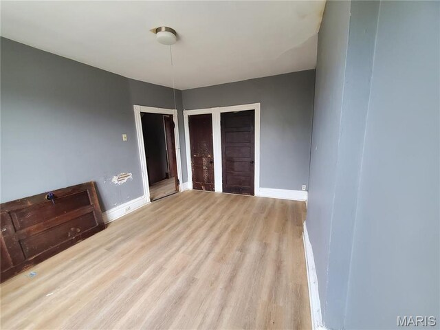 unfurnished bedroom with wood finished floors and baseboards
