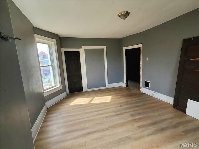 unfurnished bedroom with baseboards and light wood-style floors