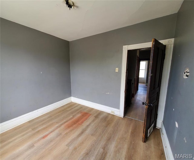 spare room with wood finished floors and baseboards