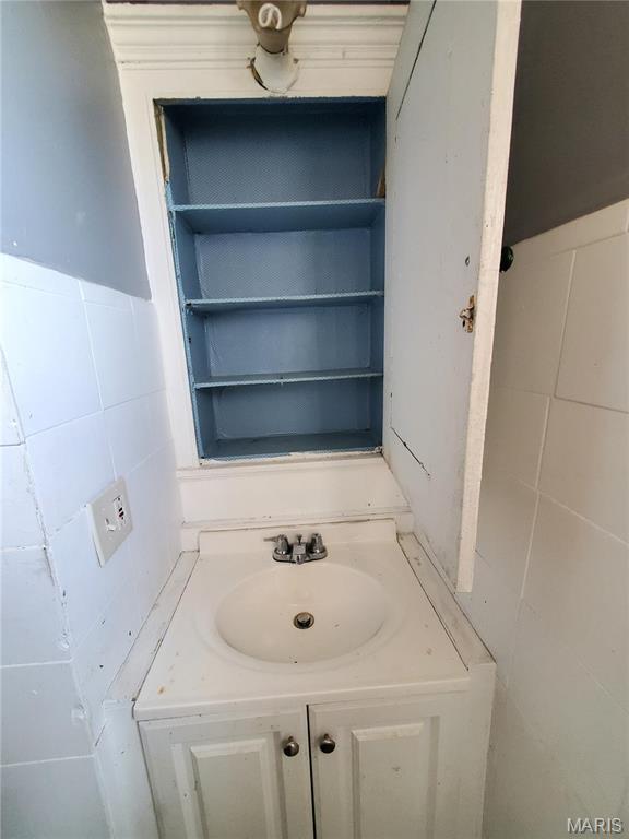 bathroom with tile walls and vanity