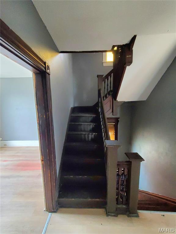 staircase with baseboards and wood finished floors