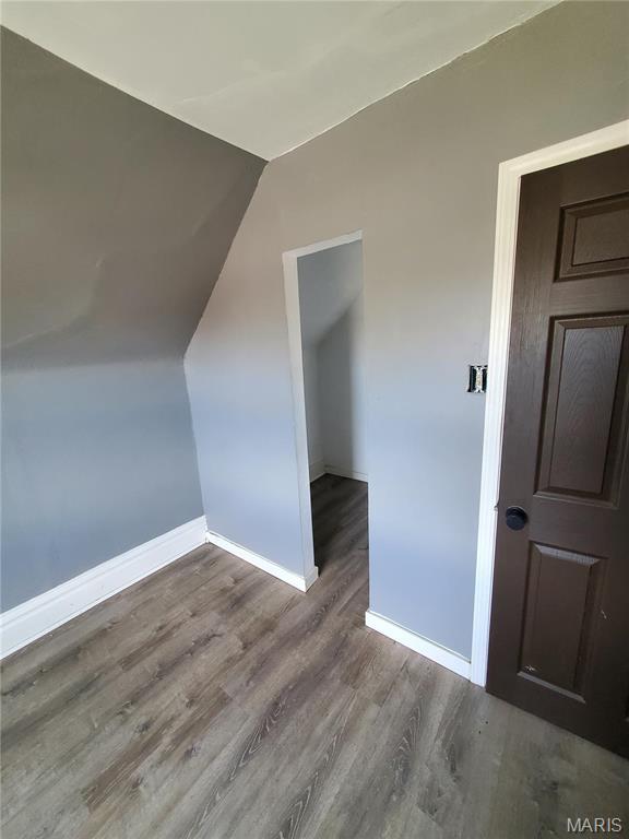 bonus room featuring baseboards, wood finished floors, and lofted ceiling