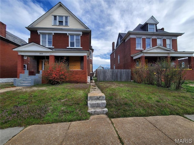 american foursquare style home featuring brick siding and a porch