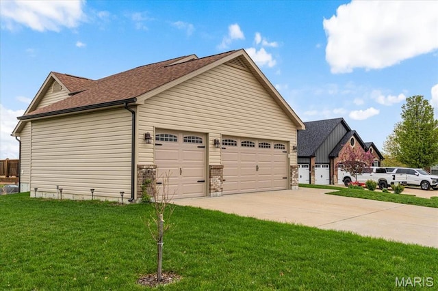 view of home's exterior with concrete driveway, a yard, a garage, and a shingled roof