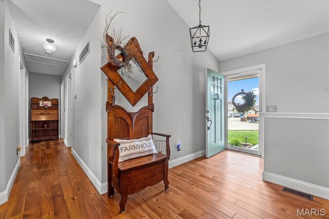 entrance foyer featuring hardwood / wood-style floors, vaulted ceiling, and baseboards