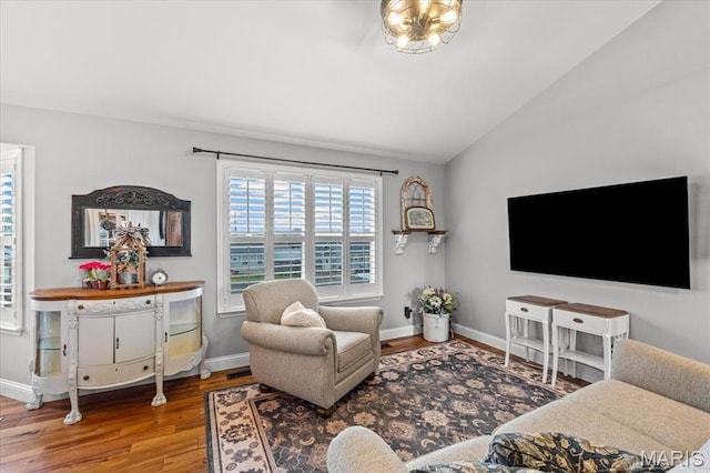 living room with wood finished floors, lofted ceiling, and baseboards
