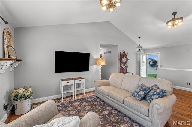 living room featuring lofted ceiling, wood finished floors, and baseboards
