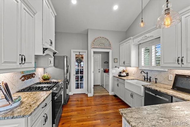 kitchen with gas stove, dishwasher, white cabinetry, wood finished floors, and vaulted ceiling