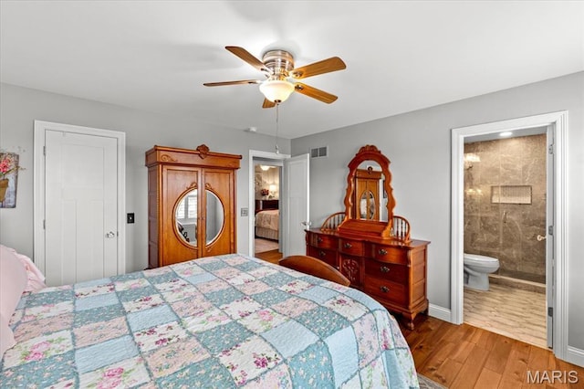 bedroom with light wood-style floors, ceiling fan, connected bathroom, and baseboards