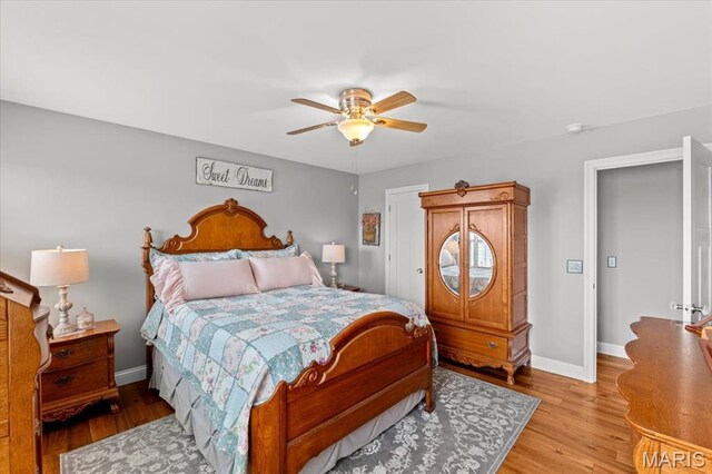 bedroom featuring wood finished floors, baseboards, and a ceiling fan