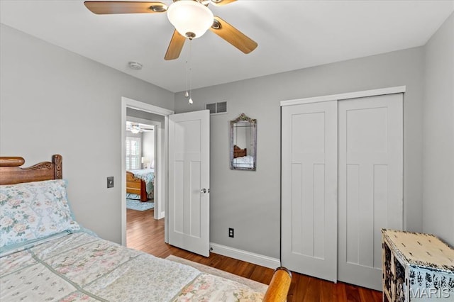bedroom with wood finished floors, a closet, a ceiling fan, and baseboards