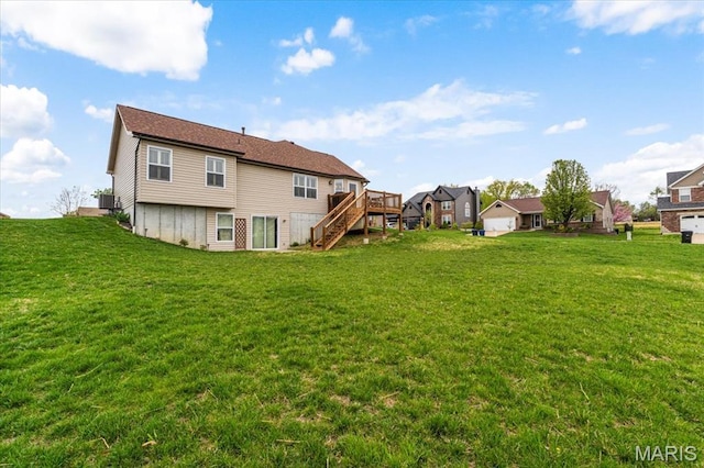 rear view of house featuring stairway, a yard, a deck, and a residential view