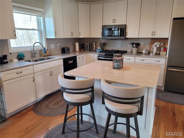123 El Rancho Dr, Hannibal, MO 63401 - kitchen with stainless steel appliances, a sink, white cabinetry, and decorative backsplash