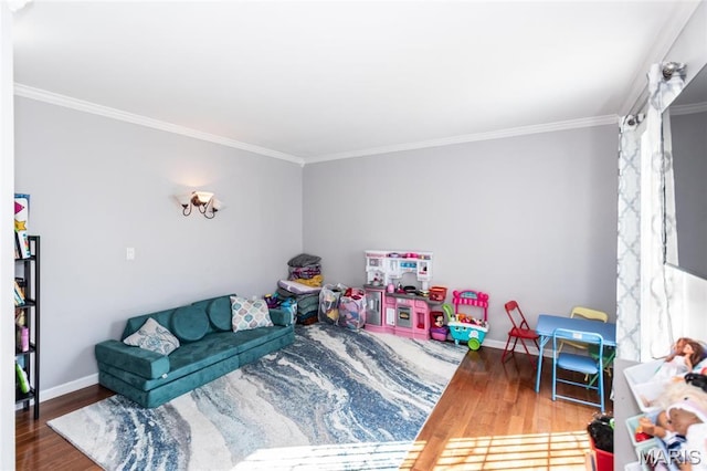 rec room featuring ornamental molding, wood finished floors, and baseboards