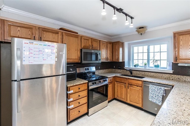 kitchen with stainless steel appliances, a sink, brown cabinetry, ornamental molding, and backsplash