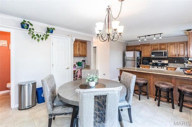 9 Shelby Crest Ct, Ofallon, MO 63366 - dining area with a chandelier, crown molding, track lighting, and light tile patterned floors