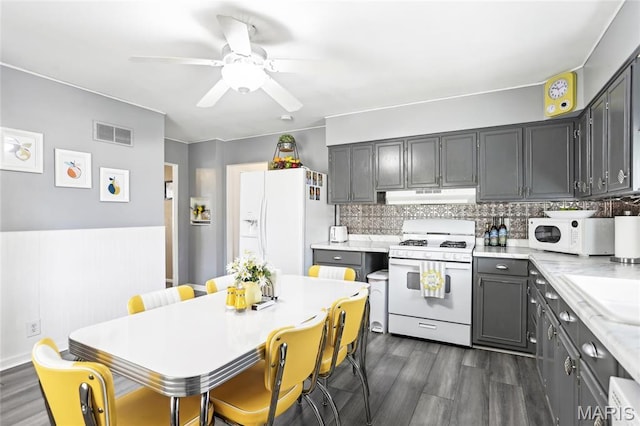 kitchen featuring white appliances, under cabinet range hood, dark wood-style flooring, and ceiling fan
