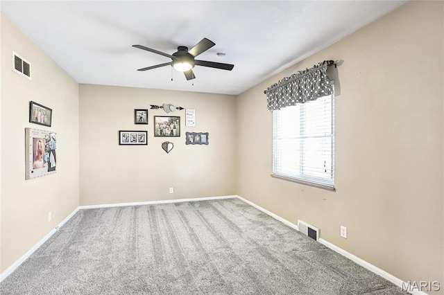 unfurnished room with carpet floors, a ceiling fan, and baseboards