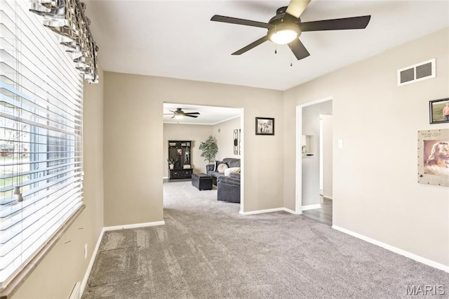 carpeted empty room featuring ceiling fan and baseboards