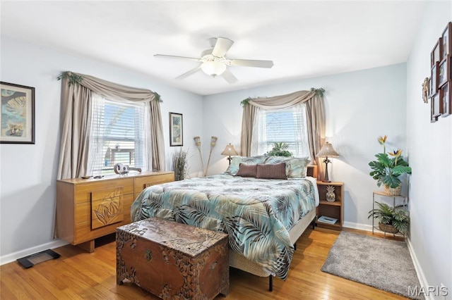 bedroom with light wood finished floors, baseboards, and ceiling fan