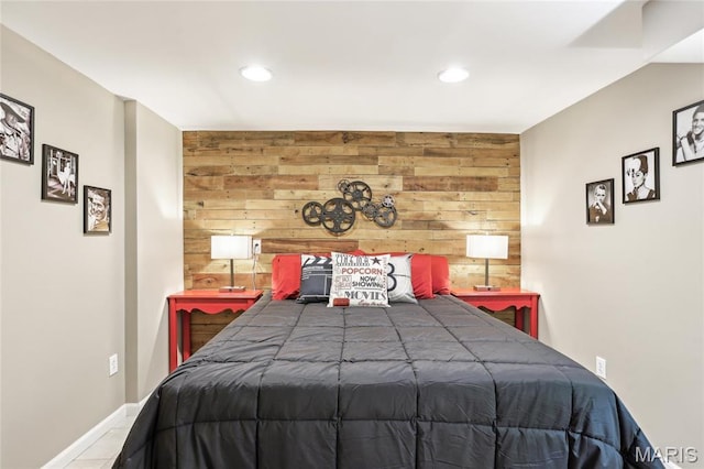 bedroom with wood walls, recessed lighting, baseboards, and an accent wall