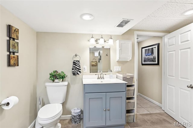 bathroom featuring toilet, vanity, tile patterned floors, and baseboards