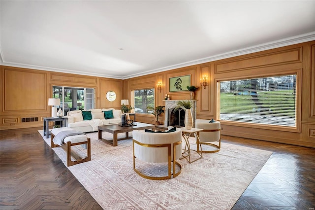 living area featuring a fireplace, ornamental molding, and a decorative wall