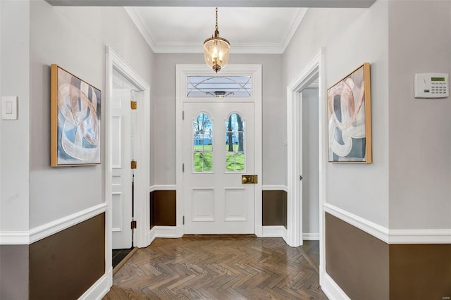 foyer entrance featuring ornamental molding and a chandelier