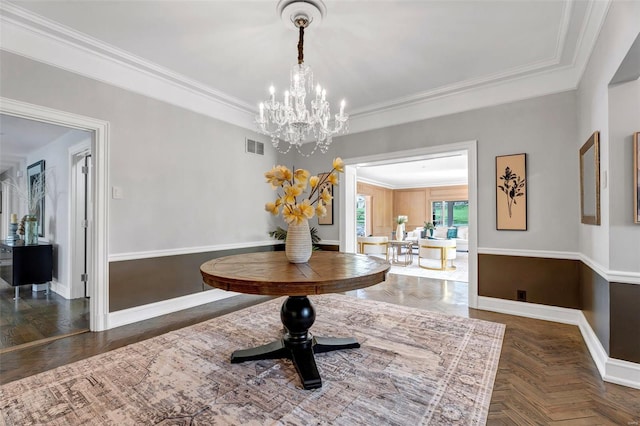 dining area featuring a chandelier, baseboards, and crown molding