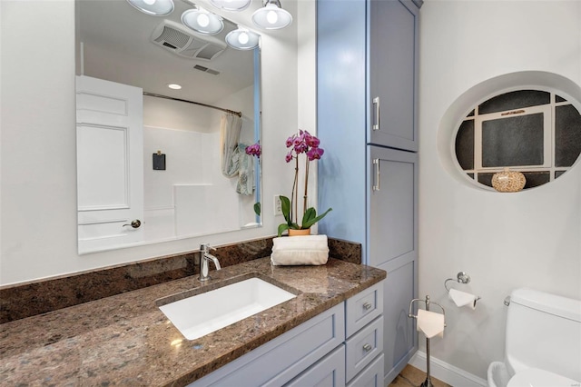 bathroom featuring toilet, vanity, and a shower with shower curtain